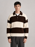 Man wearing a brown and cream striped knit polo sweater, front view on a light grey studio background