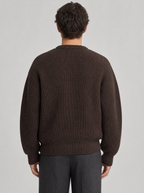 Back view of a brown drop shoulder chunky knit sweater showing the shoulder line and sleeves