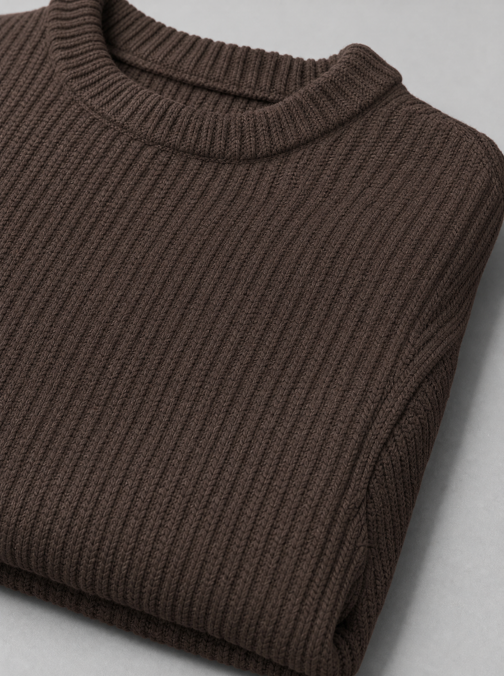 Close up of the ribbed crew neck and pearl stitch texture on a brown chunky knit sweater