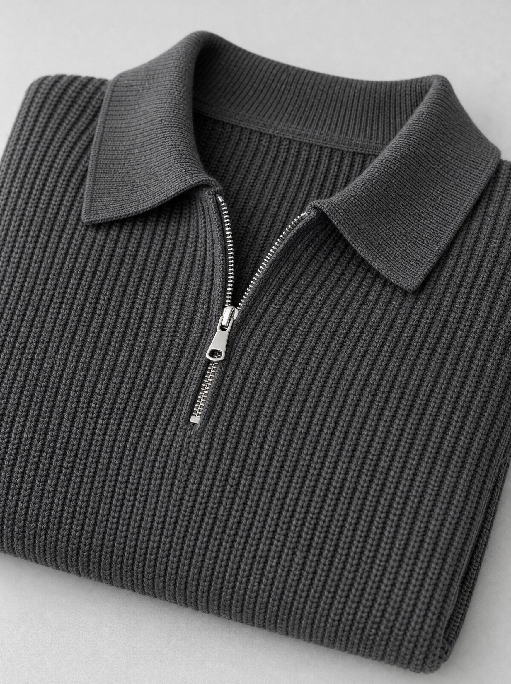 Close up of the collar, zip and knit texture on a charcoal half zip pullover