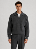 Man wearing a charcoal half zip knit pullover, front view on a light grey studio background
