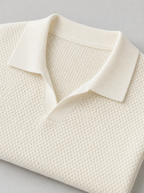 Close up of the open collar and raised knit texture on a cream short sleeve polo