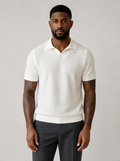 Man wearing a cream textured knit short sleeve polo, front view on a light grey studio background