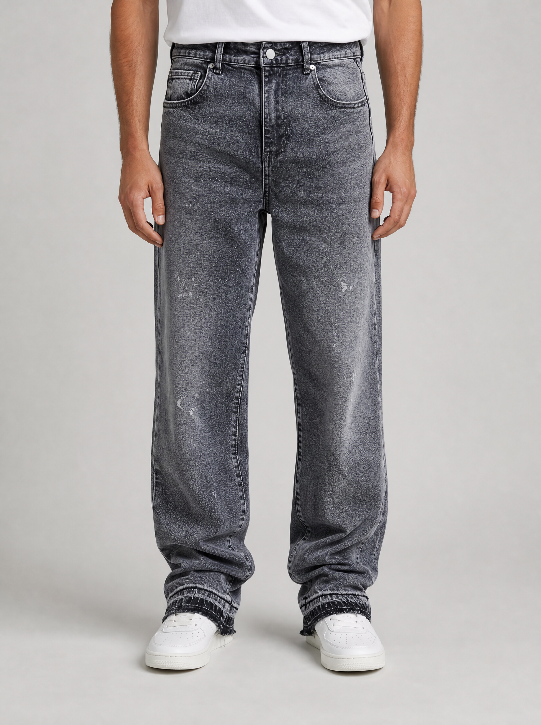 Man wearing frost wash flare leg jeans, front view on a light grey studio background