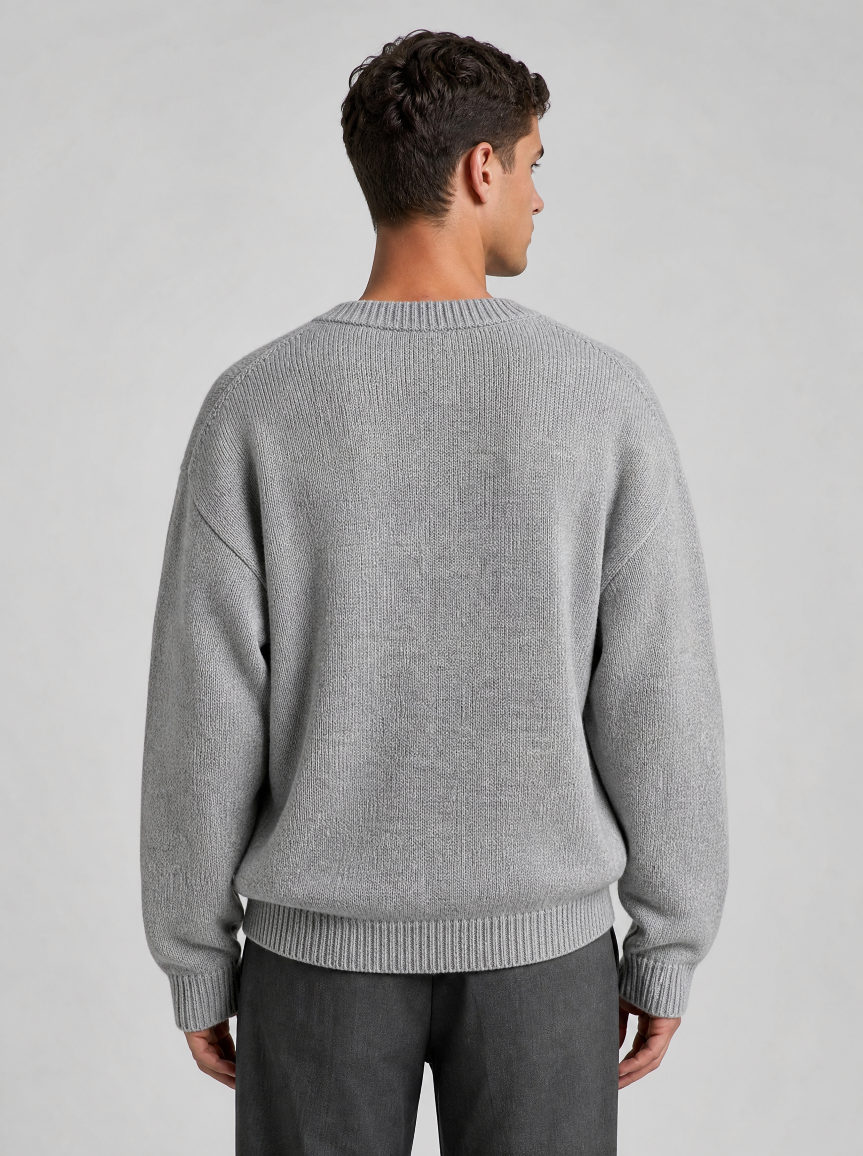 Back view of a light grey oversized knit sweater showing the shoulder line and sleeves