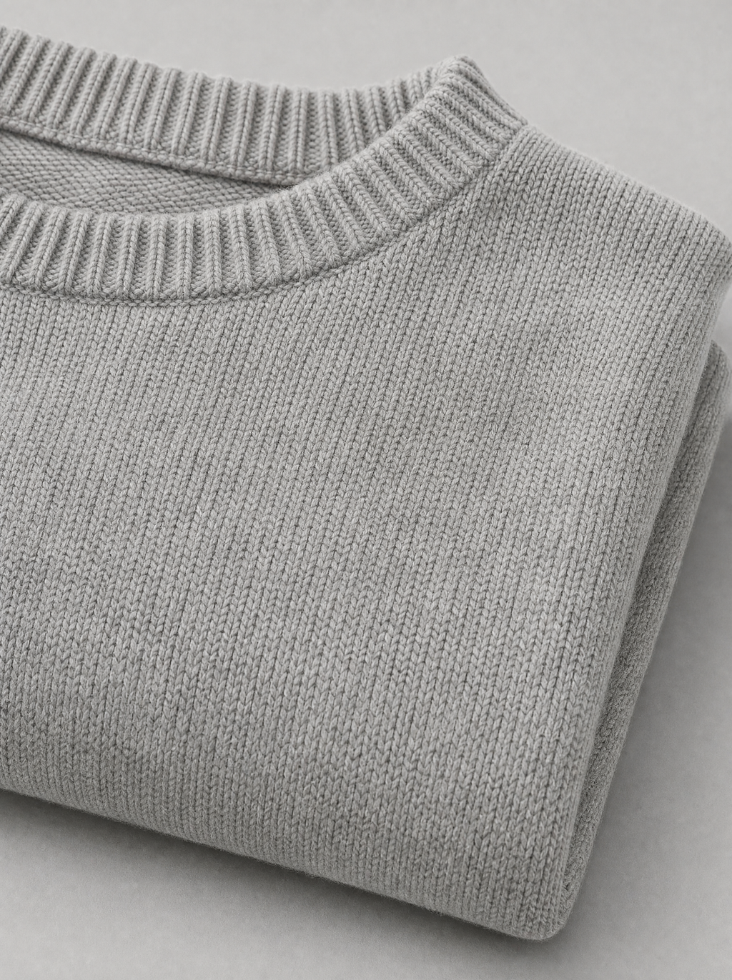 Close up of the wide ribbed crew neck and knit texture on a light grey oversized sweater