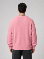 Back view of a pink knit sweater showing the shoulder line and sleeves