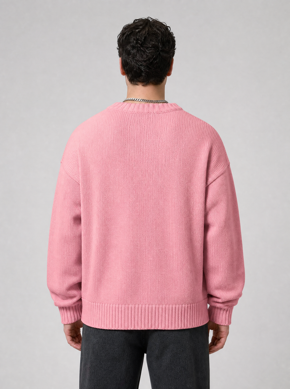 Back view of a pink knit sweater showing the shoulder line and sleeves