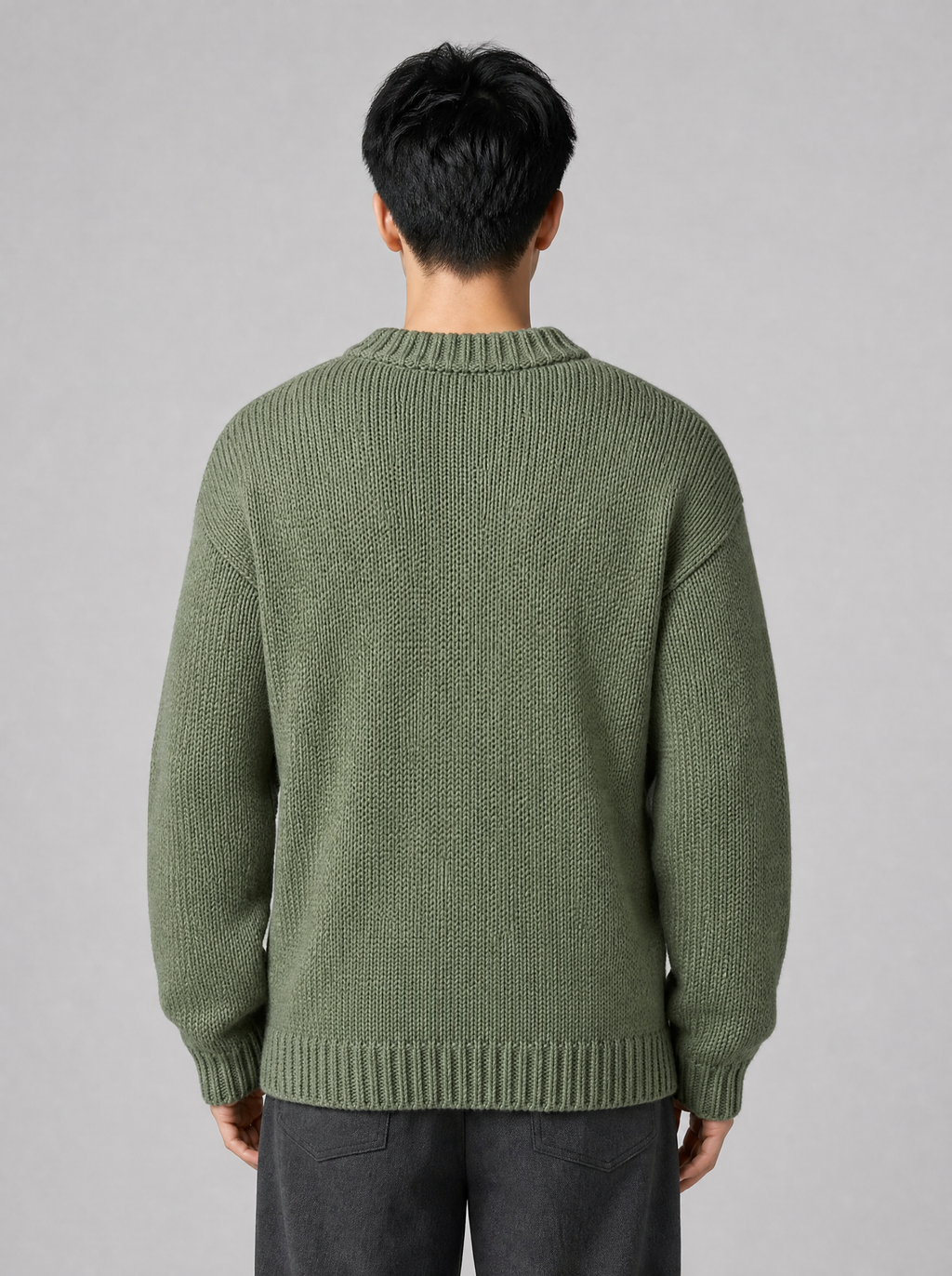Back view of a sage green drop shoulder knit sweater showing the shoulder line and sleeves