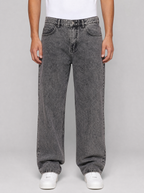 Man wearing smoke grey washed relaxed straight jeans, front view on a light grey studio background