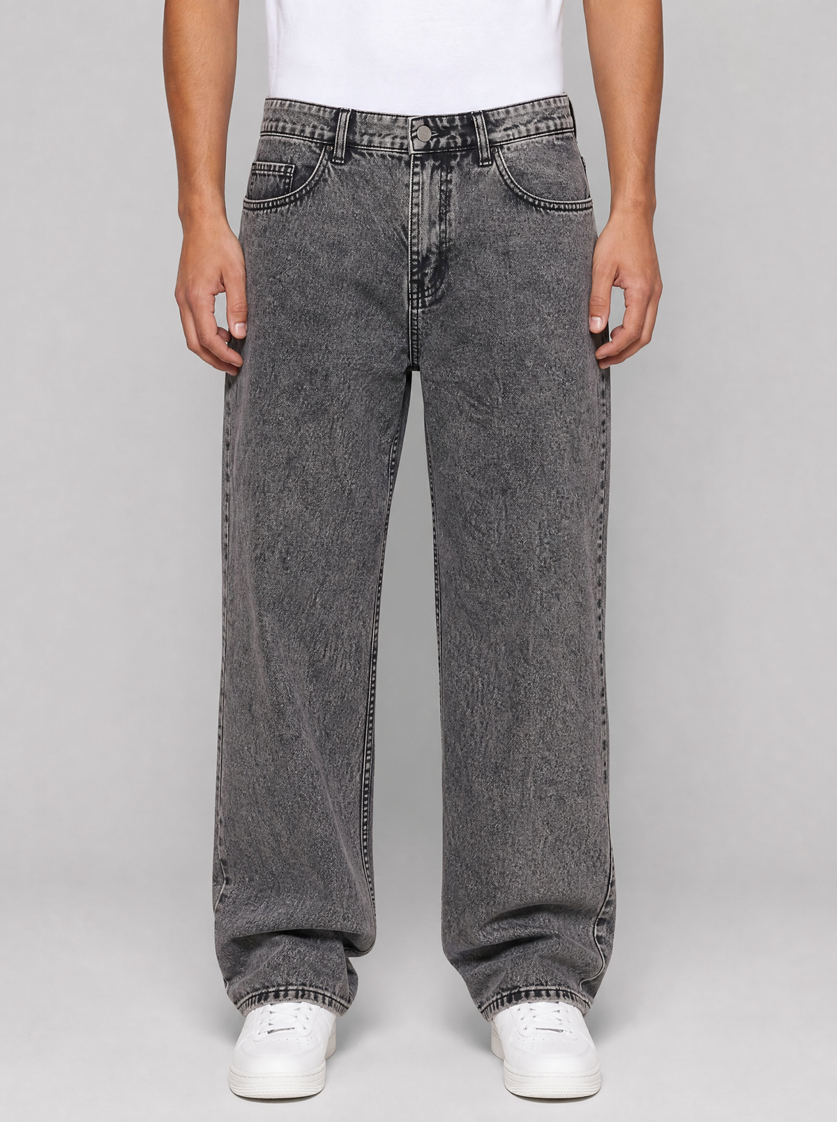 Man wearing smoke grey washed relaxed straight jeans, front view on a light grey studio background