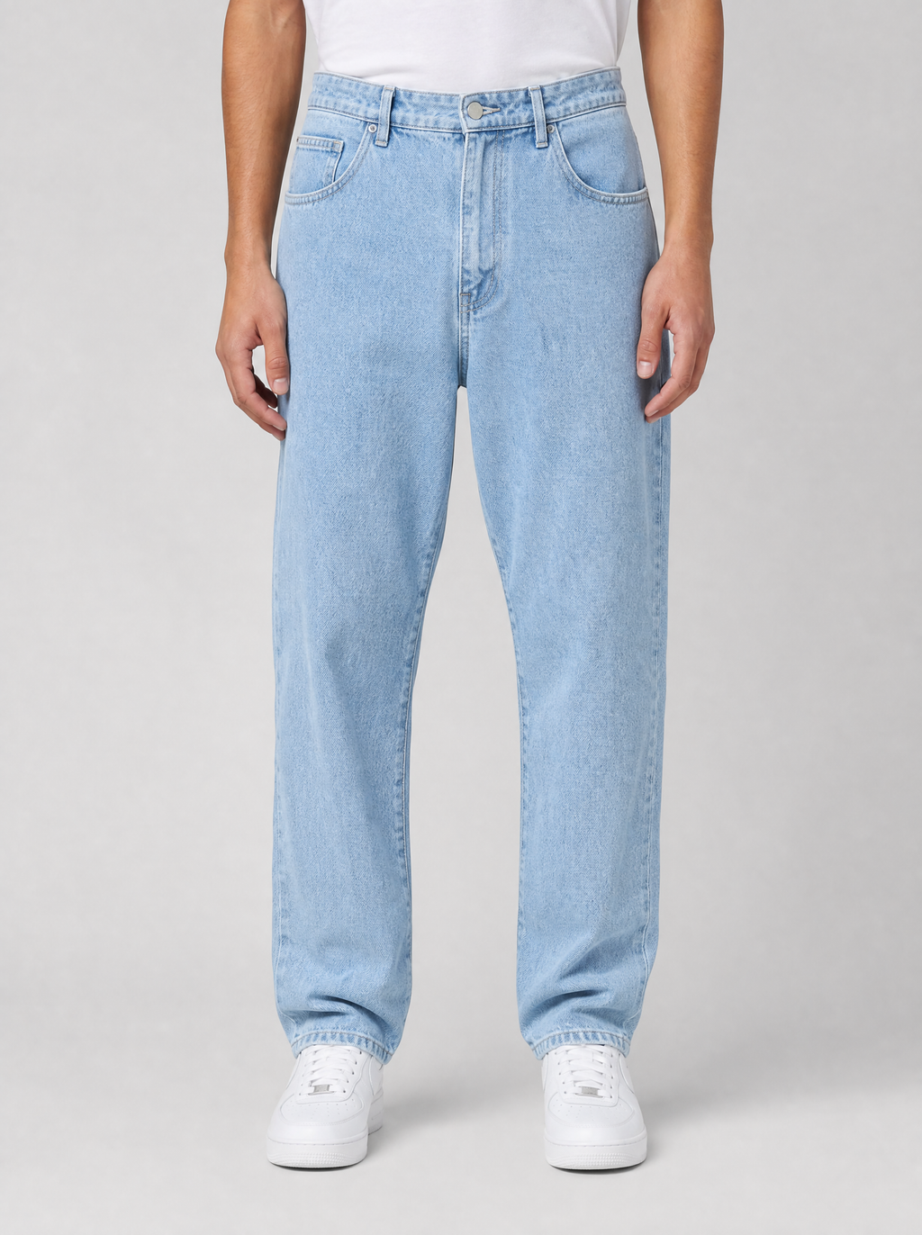 Man wearing stretch denim regular fit jeans, front view on a light grey studio background
