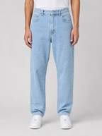 Man wearing stretch denim regular fit jeans, front view on a light grey studio background