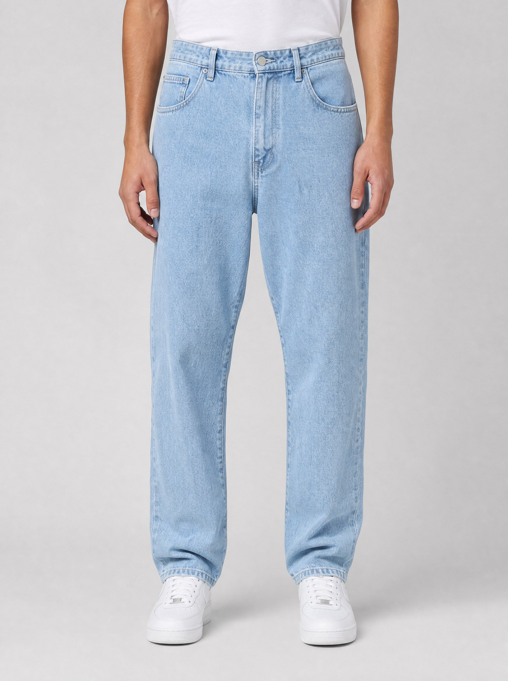 Man wearing stretch denim regular fit jeans, front view on a light grey studio background