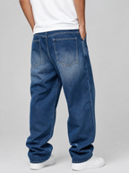 Back view of whiskered wash loose straight jeans showing the back pockets and yoke
