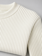 Close up of the ribbed crew neck and vertical rib texture on a white knit sweater