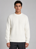 Man wearing a white ribbed knit crewneck sweater, front view on a light grey studio background
