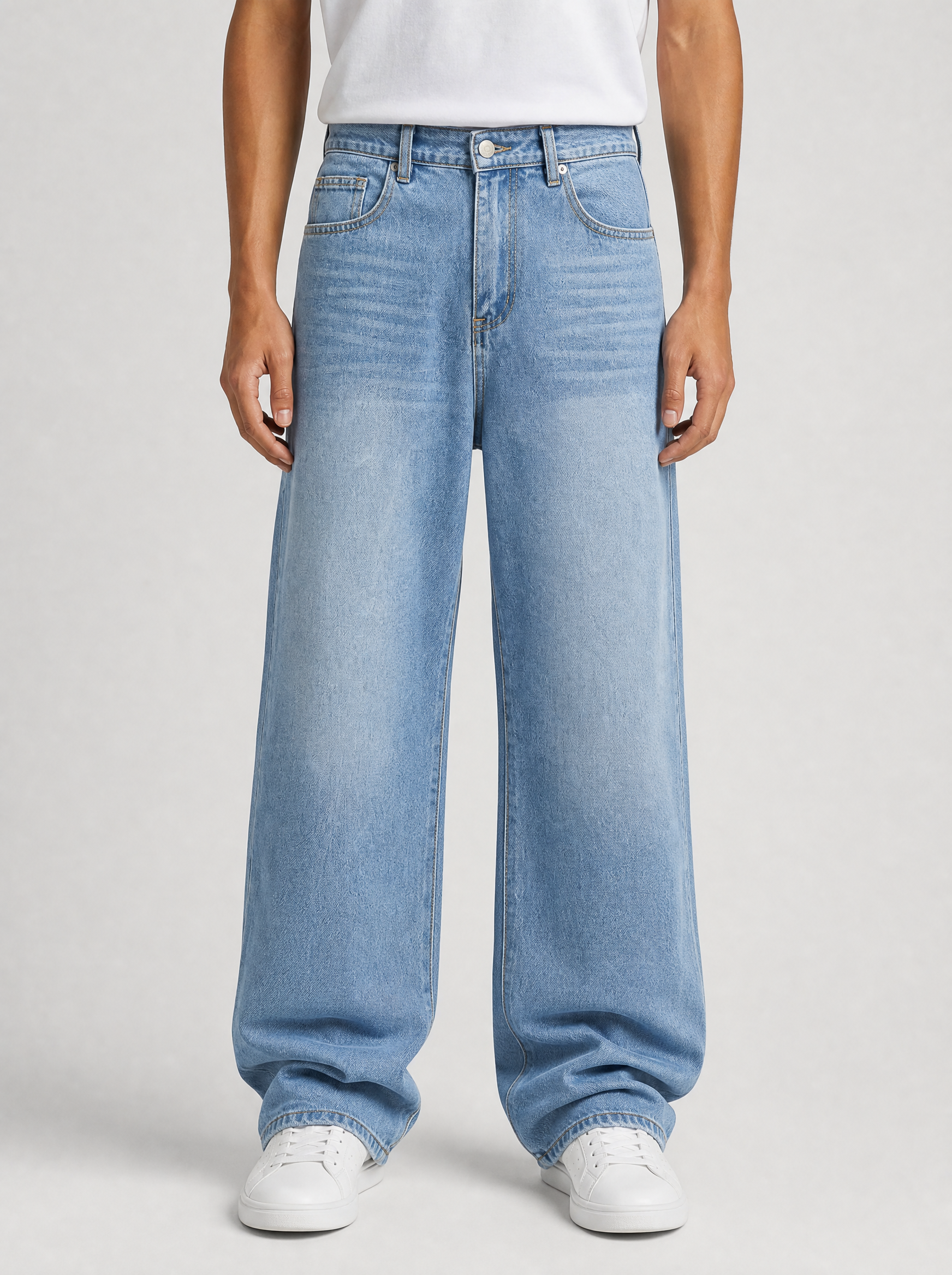 Man wearing Y2K baggy wide leg jeans, front view on a light grey studio background